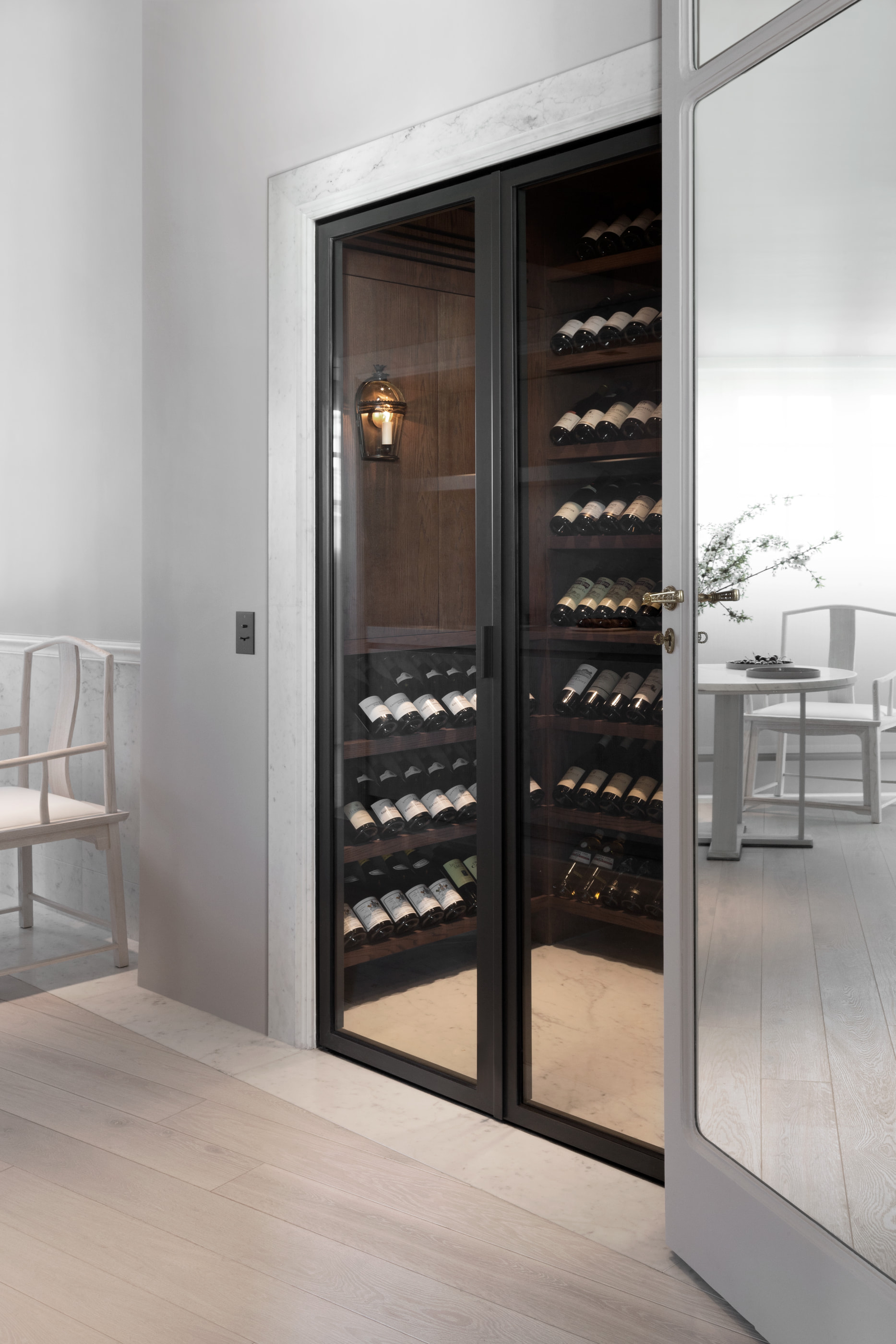 Kennedy Residence by Guillaume Alan — glazed wine cellar, bottle racks and chair, residence in Paris