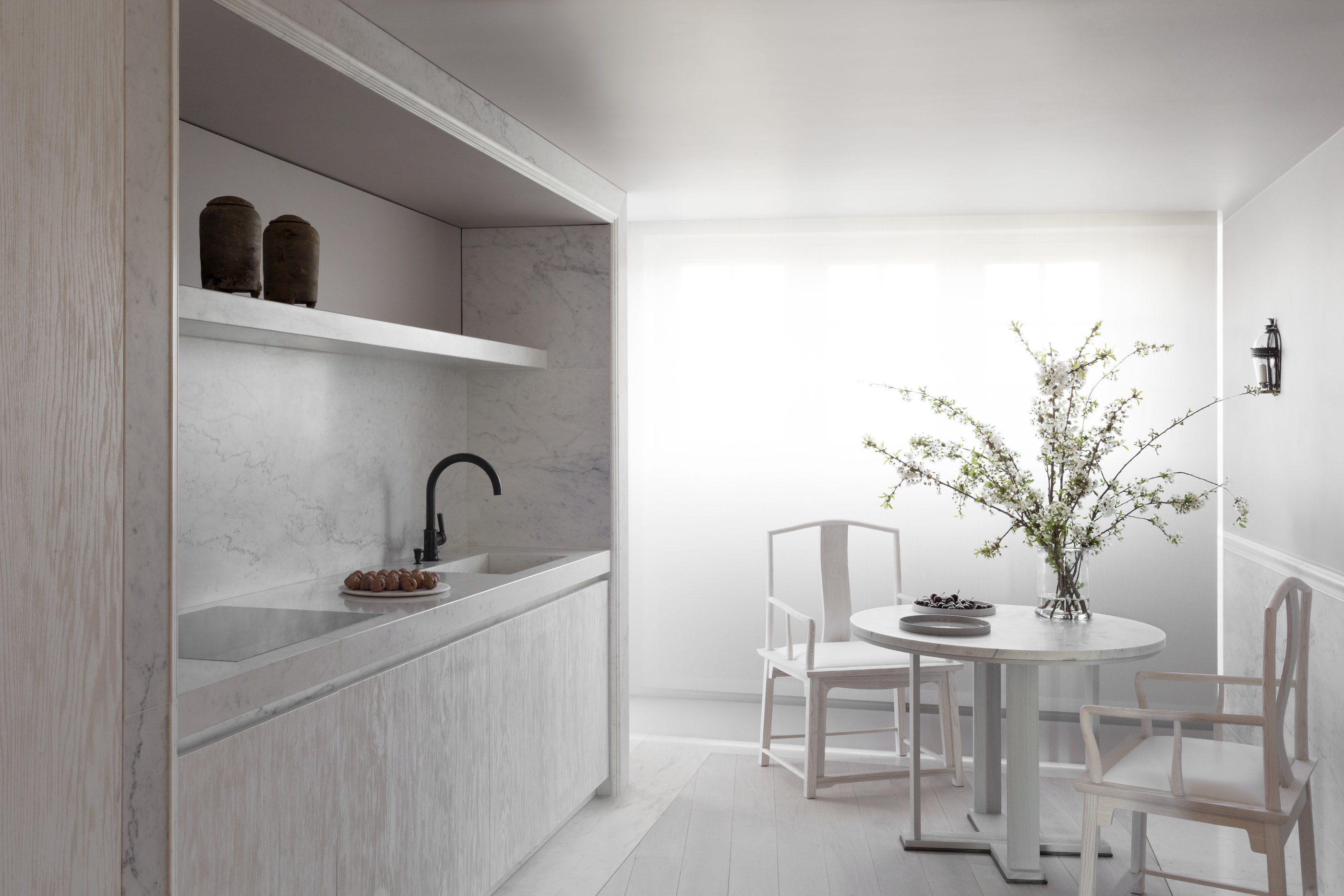 Kennedy Residence by Guillaume Alan — marble pantry, black tap, table and chairs beyond, residence in Paris