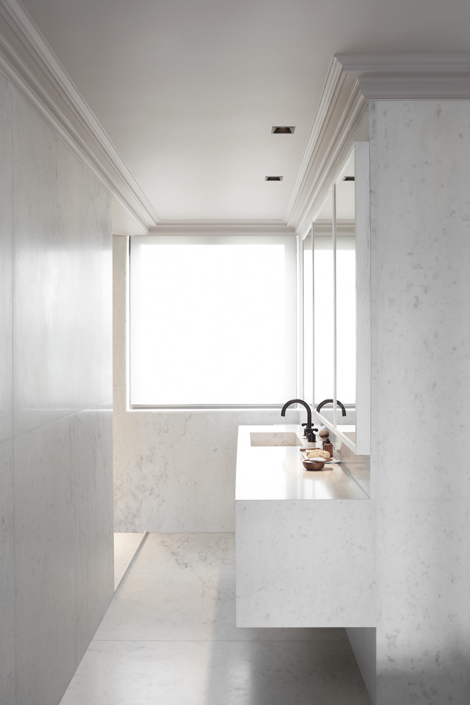 Kennedy Residence by Guillaume Alan — bathroom in enfilade, marble washbasin counter beyond, residence in Paris