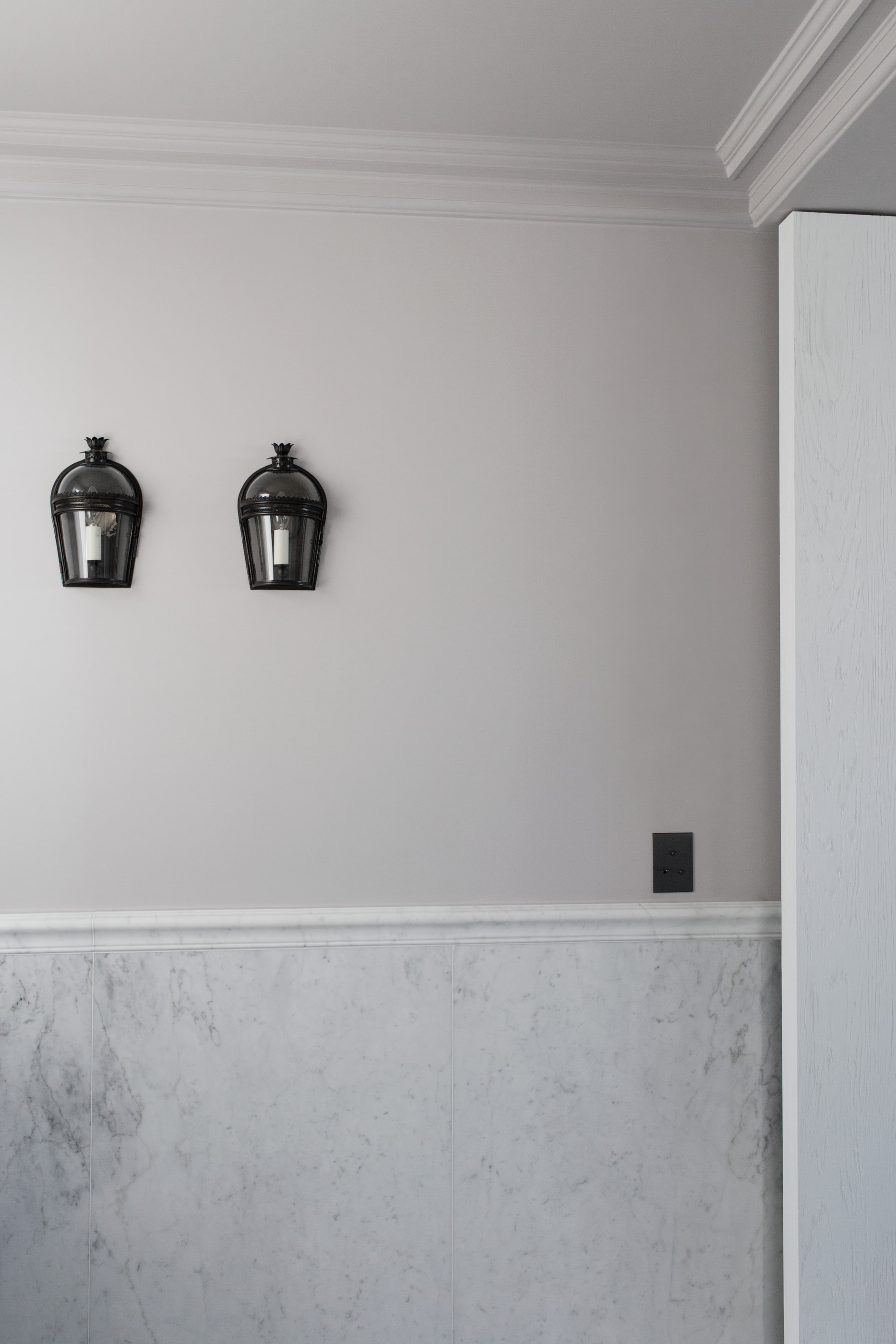 Kennedy Residence by Guillaume Alan — wall with two black lanterns and marble base, residence in Paris