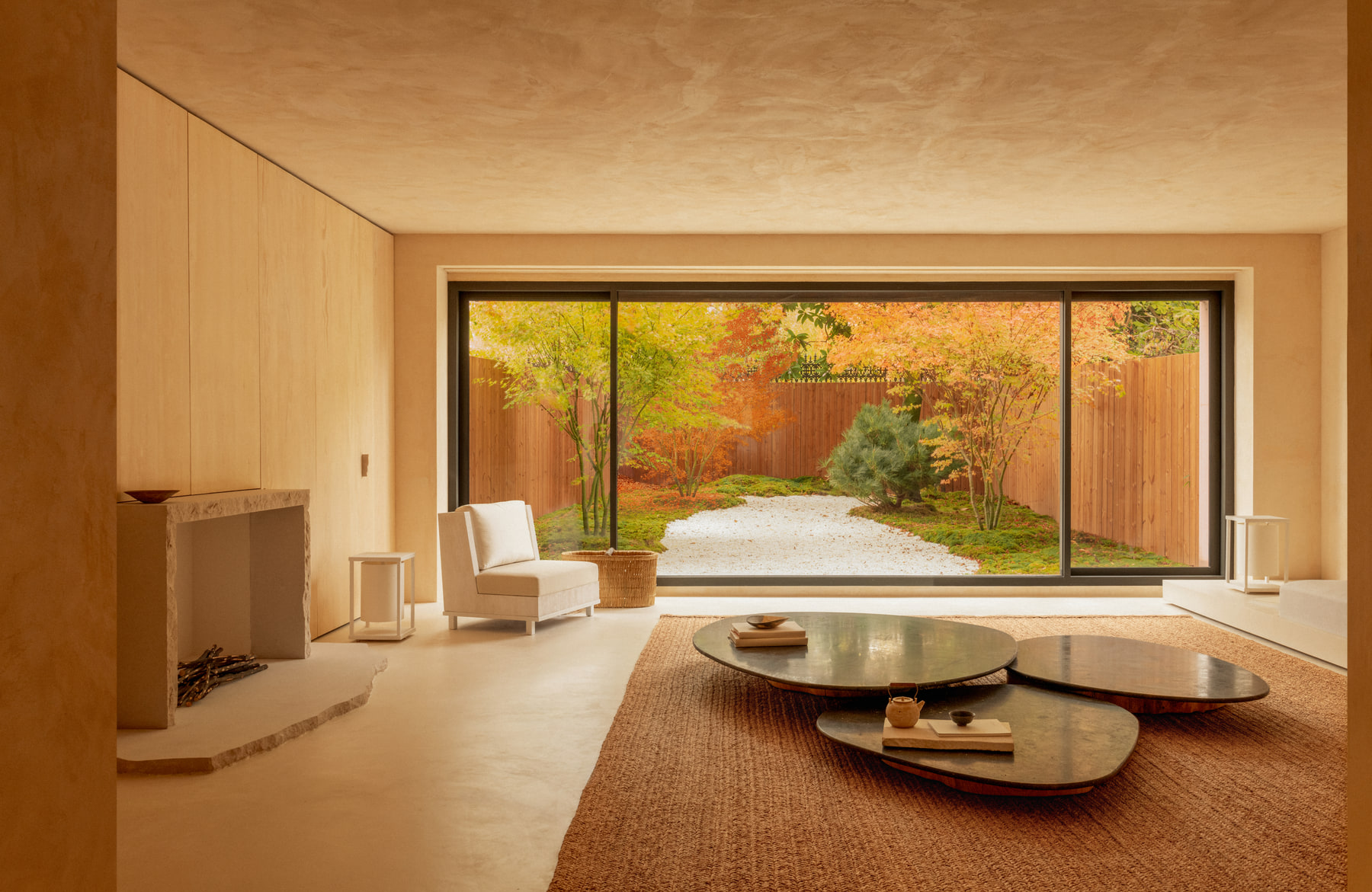 L’Imparfait by Guillaume Alan — living room opening onto the garden through a picture window, low round table, apartment in Paris