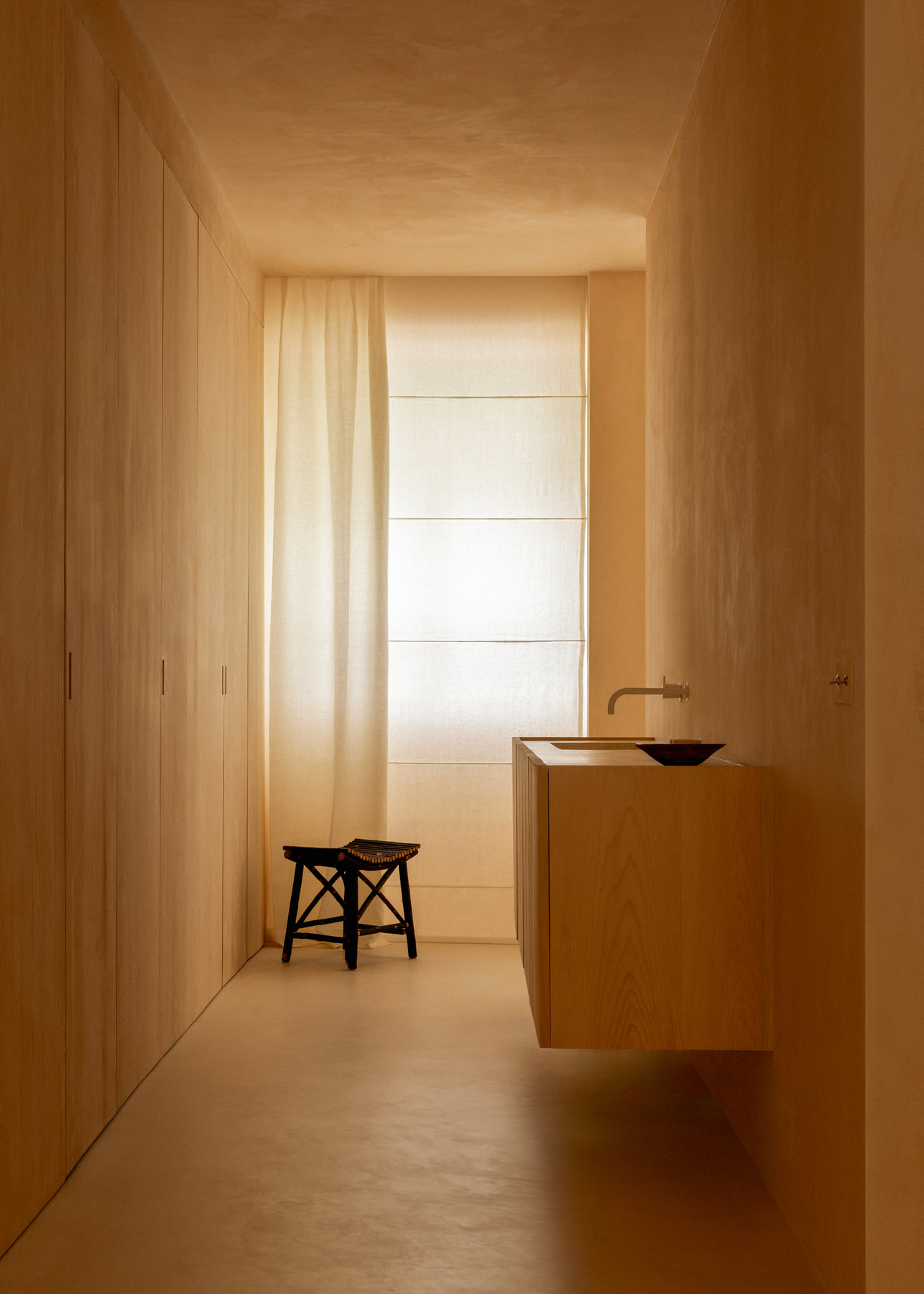 L’Imparfait by Guillaume Alan — bathroom niche with wooden stool and basin, linen curtain, apartment in Paris