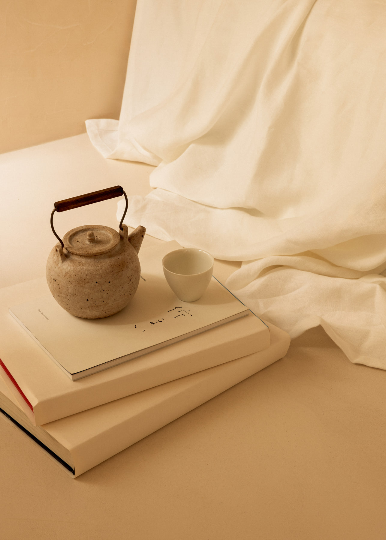 L’Imparfait by Guillaume Alan — teapot and books on linen, apartment in Paris
