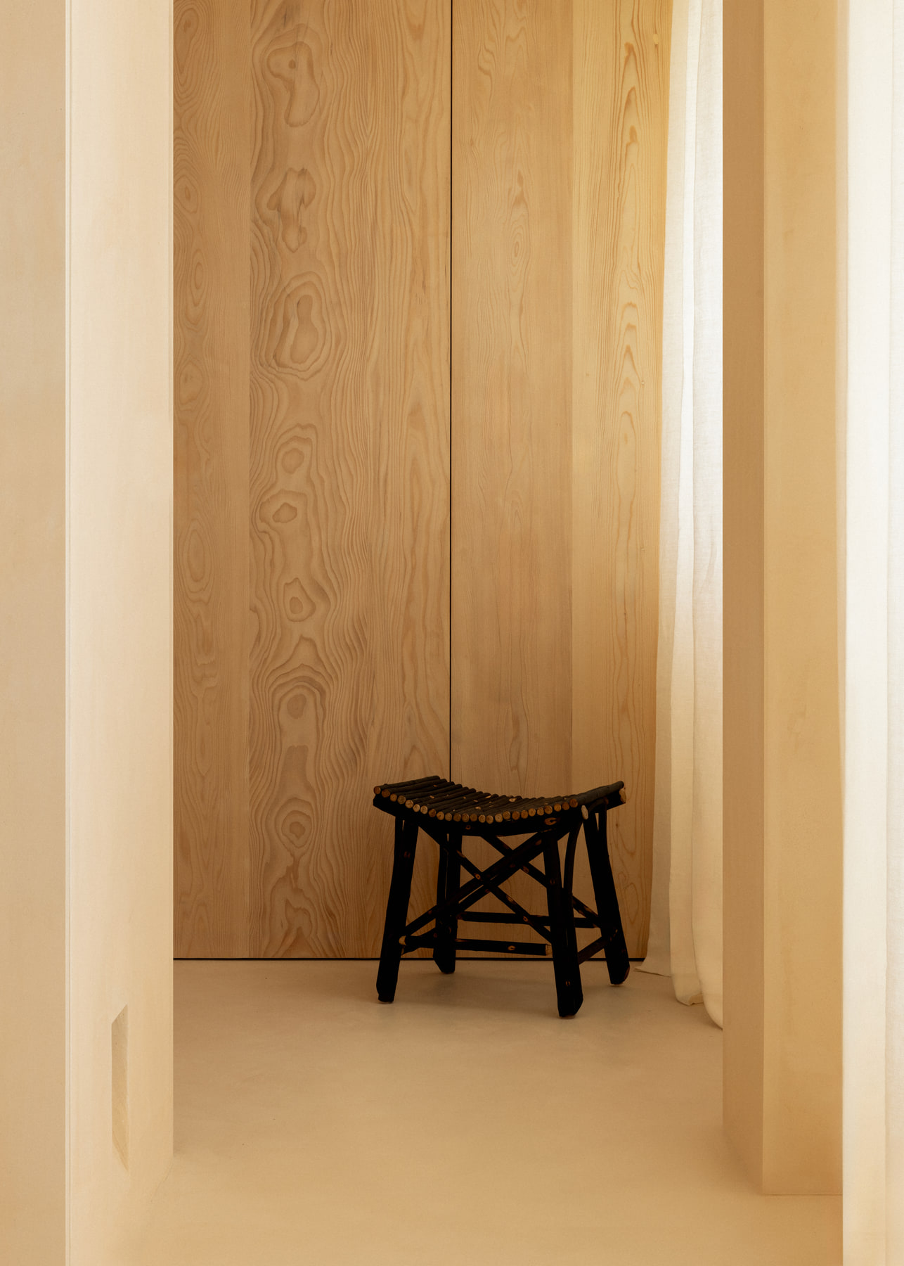 L’Imparfait by Guillaume Alan — wooden stool in a plaster niche, apartment in Paris