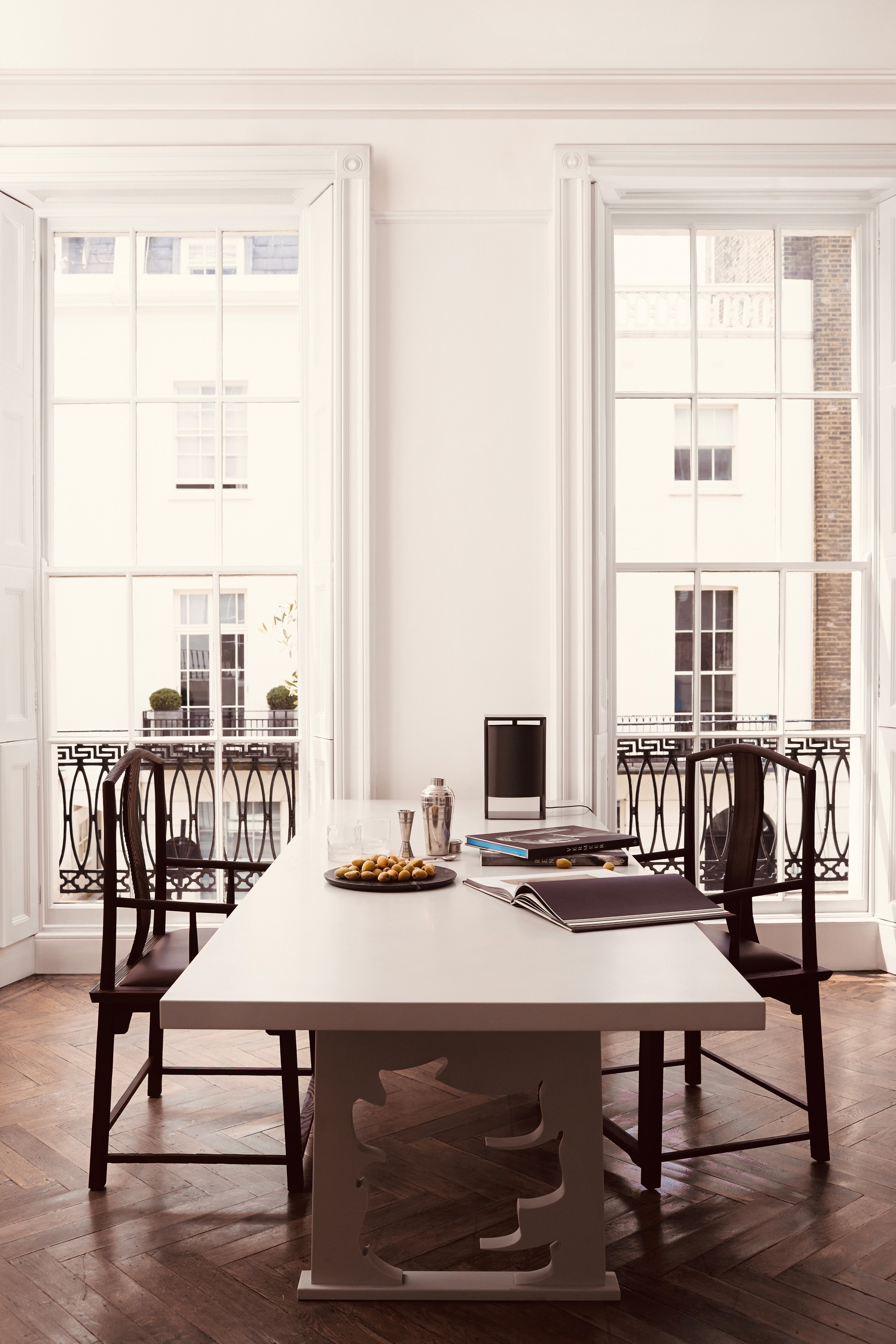 Mayfair House by Guillaume Alan — dining room, Corian table and Ming-inspired chairs between two tall windows, residence in London