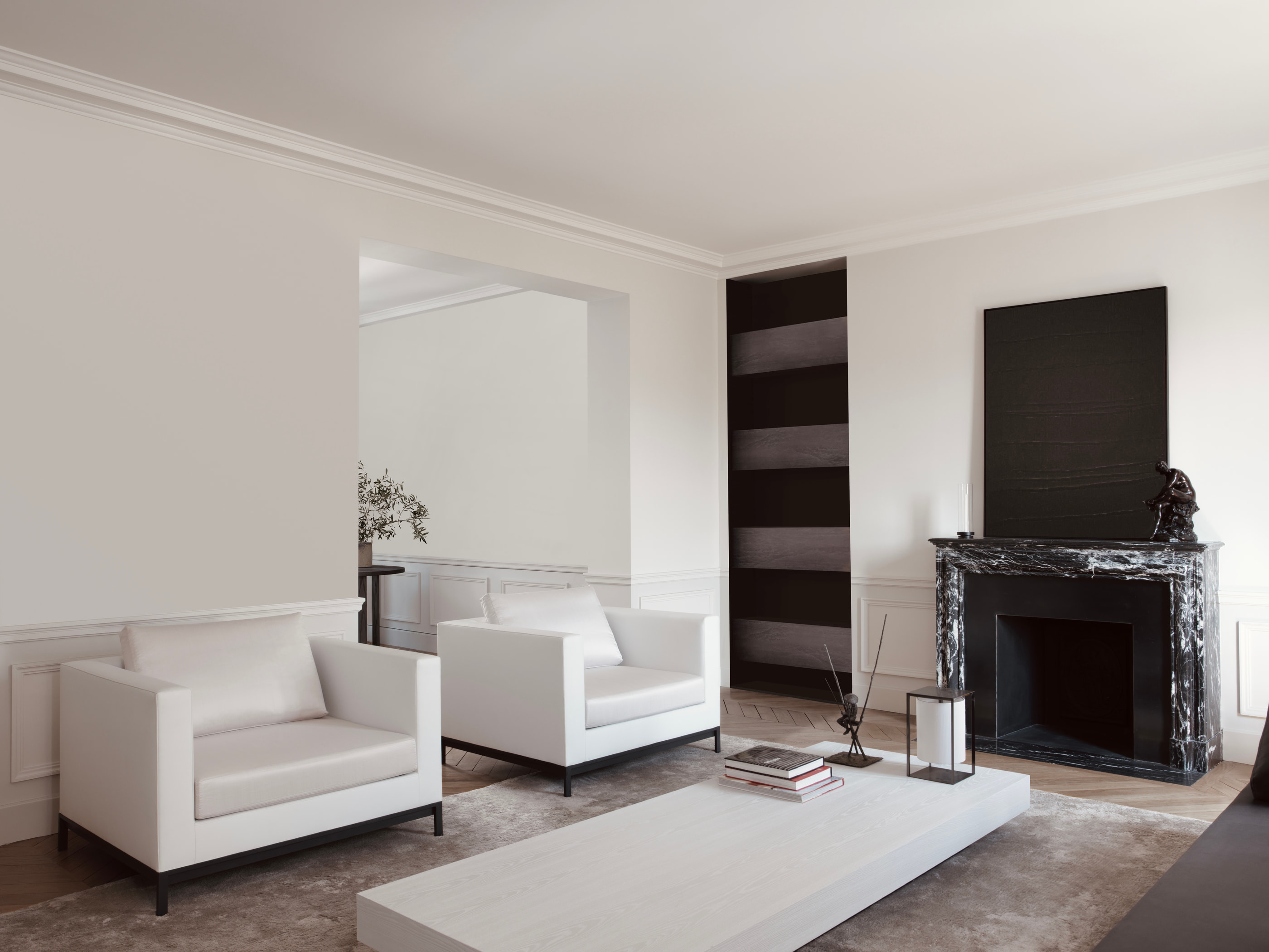 VH Penthouse by Guillaume Alan — living room, white armchairs facing the black marble fireplace, apartment in Paris