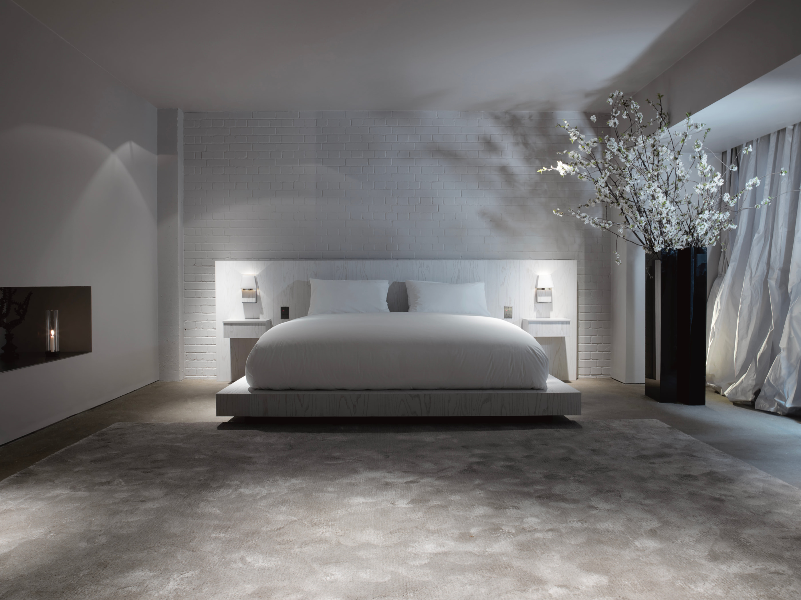 VH Penthouse by Guillaume Alan — bedroom, upholstered headboard and blossoming branch, apartment in Paris